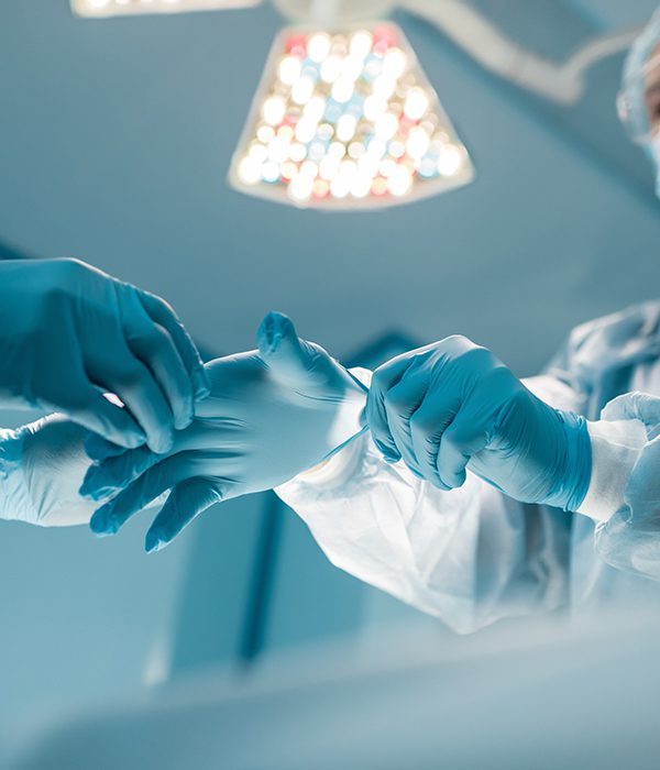 cropped image of nurse helping surgeon wear medical gloves